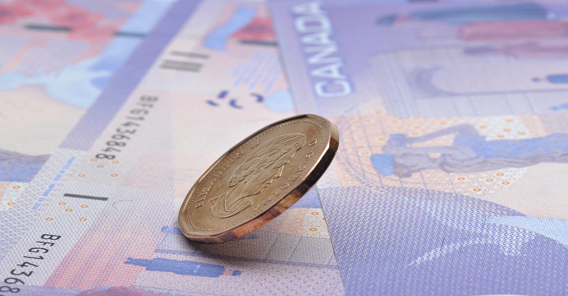canadian loonie falling on table
